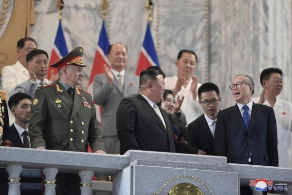 North Korean leader Kim Jong Un (C) talks with Chinese Communist Party Politburo member Li Hongzhong (R) as they and Russian Defense Minister Sergei Shoigu (L) attend a military parade to mark the 70th anniversary of the armistice that halted fighting in the 1950–53 Korean War, on Kim Il Sung Square in Pyongyang, North Korea, on July 27, 2023. (Korean Central News Agency/Korea News Service via AP)