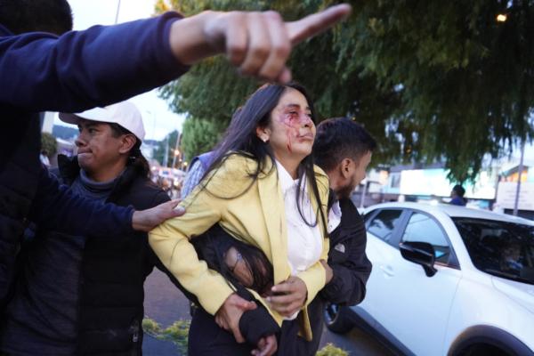 A woman is assisted after being wounded after shots were fired at the end of a rally of Ecuadorian presidential candidate Fernando Villavicencio in Quito, Ecuador, on Aug. 9, 2023. (AFP via Getty Images)