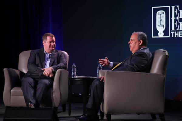 Talk show host Erick Erickson (left) listens as former New Jersey Gov. Chris Christie speaks at "The Gathering" in Atlanta on Aug. 19, 2023. (Justin Kase/The Epoch Times)