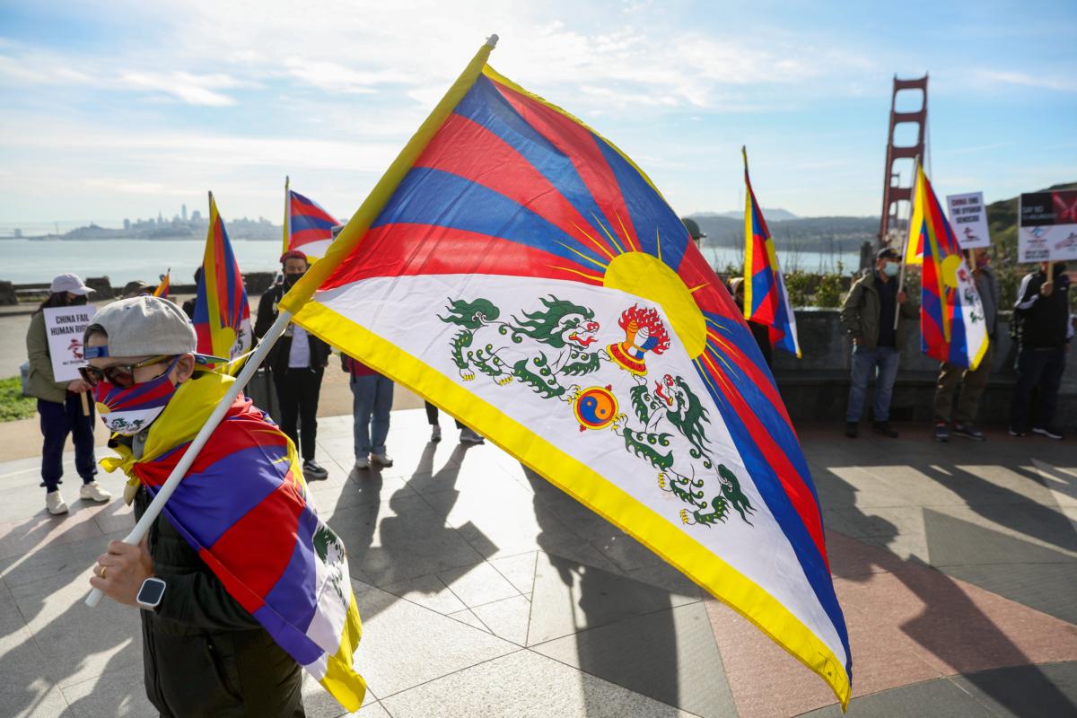 People hold signs during a protest against the 2022 Beijing Winter Olympics over the Chinese regime's human rights crisis in Xinjiang, in Sausalito, Calif., on Feb. 3, 2022. (Justin Sullivan/Getty Images)