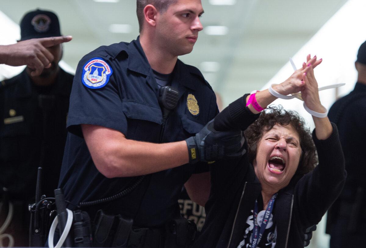 U.S. Capitol Police arrest demonstrators for protesting against Judge Brett Kavanaugh's nomination to the Supreme Court as the U.S. Senate Judiciary Committee considers his nomination on September 28, 2018. (Saul Loeb/AFP via Getty Images)