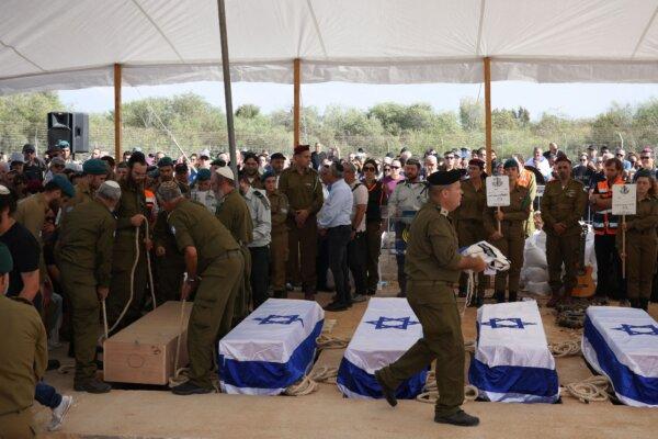 People mourn by the coffins of five members of the Kutz family who were killed in a Palestinian terrorists attack on their kibbutz of Kfar Aza, during their funeral in Gan Yavne town in central Israel, on Oct. 17, 2023. (Oren Ziv/AFP via Getty Images)