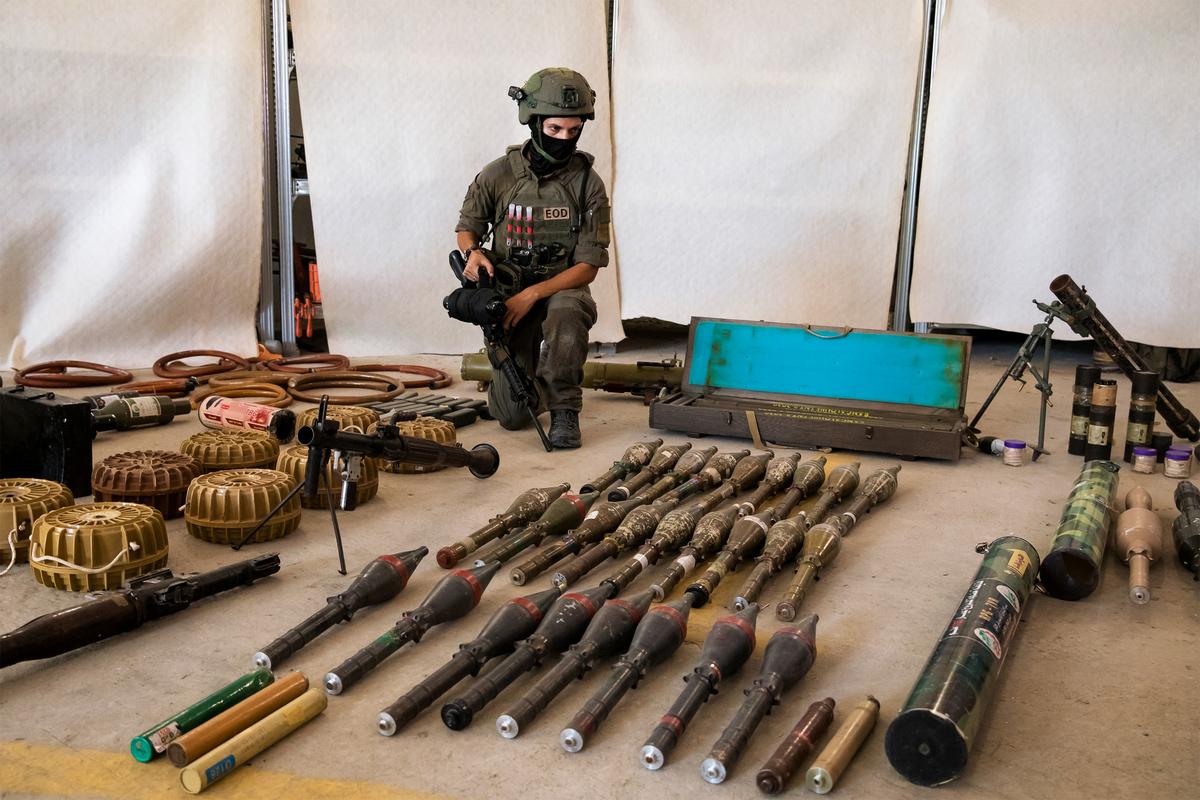 An Israeli soldier displays military equipment and ammunition that Hamas and Palestinans militants used at the time of the attack on the Israeli south border with the Gaza Strip in Kiryat Malakhi, Israel, on Oct. 20, 2023. (Amir Levy/Getty Images)