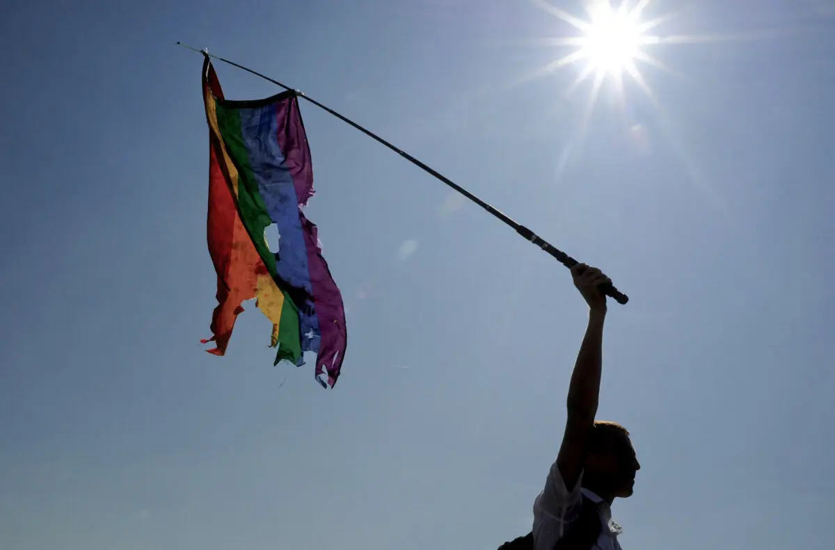 An activist waves a damaged rainbow flag during gay pride in St. Petersburg on July 26, 2014. (Olga Maltseva/AFP via Getty Images)