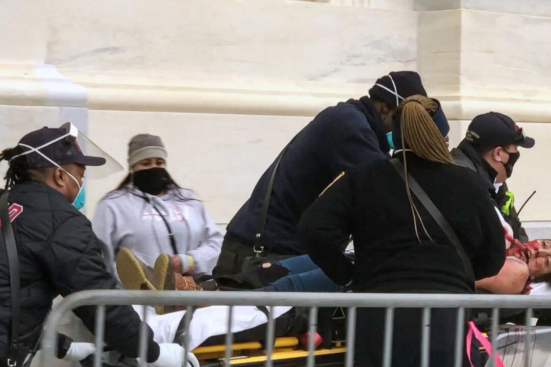 Paramedics rush a mortally wounded Ashli Babbitt to the rescue squad just after 3 p.m. on Jan. 6, 2021. (Steve Baker/Special to The Epoch Times)