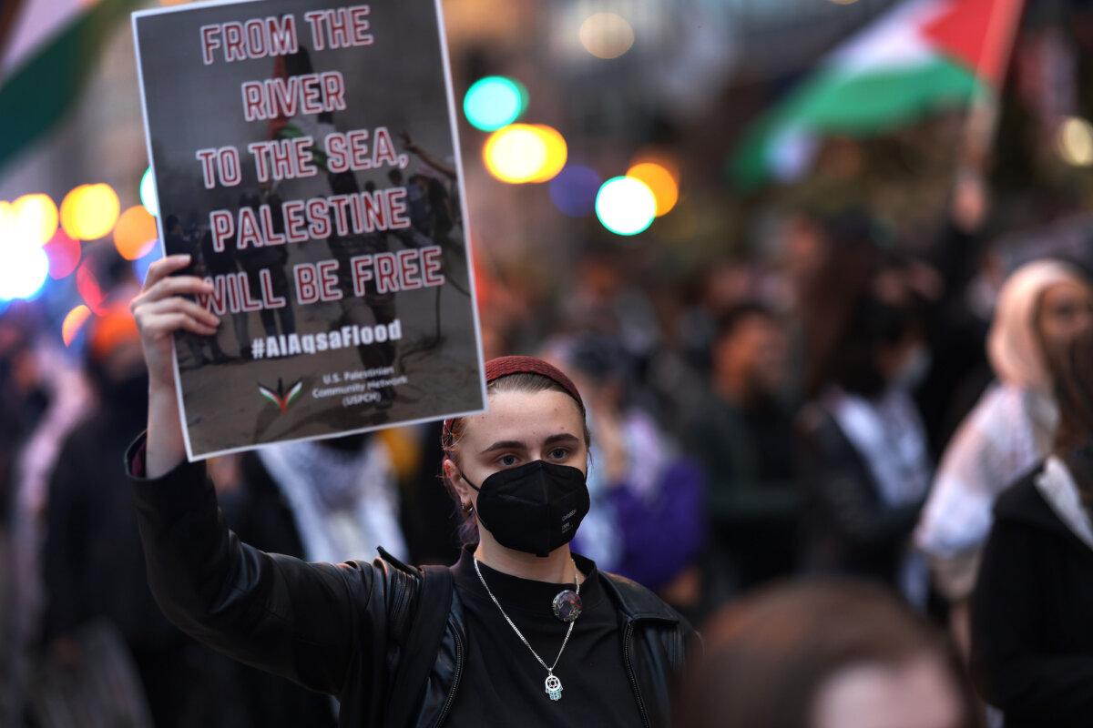 A demonstrator holds a sign reading '"From the river to the sea, Palestine will be free" at a pro-Palestinian rally in Chicago on Oct. 11, 2023. (Scott Olson/Getty Images)