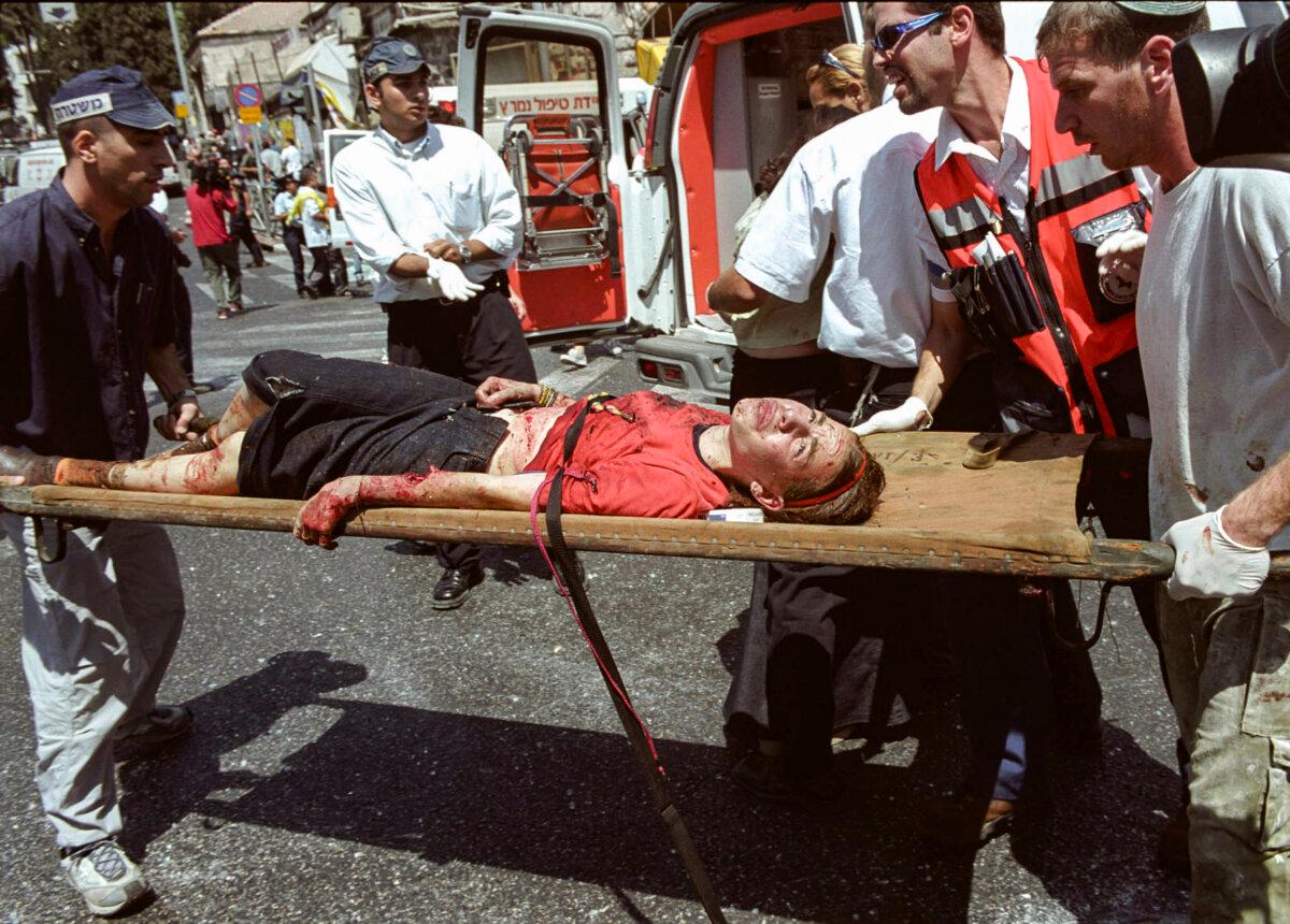 Israeli medics evacuate an injured woman from the site of a suicide bombing in Jerusalem on Aug. 9, 2001. (Getty Images)