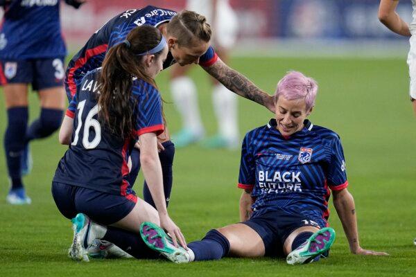 OL Reign forward Megan Rapinoe (R) stays down after an injury as teammates midfielder Rose Lavelle (16) and midfielder Jess Fishlock (C) check on her during the first half of the NWSL Championship soccer game against NJ/NY Gotham in San Diego on Nov. 11, 2023. (Gregory Bull/AP Photo)