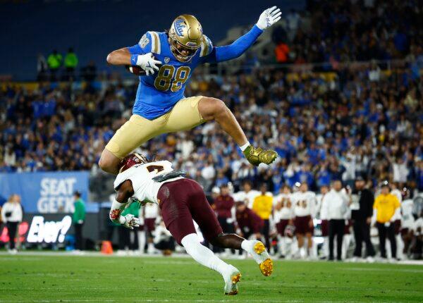 Moliki Matavao (88) of the UCLA Bruins jumps over Shamari Simmons (7) of the Arizona State Sun Devils in the second quarter at Rose Bowl Stadium in Pasadena, Calif., on Nov. 11, 2023. (Ronald Martinez/Getty Images)