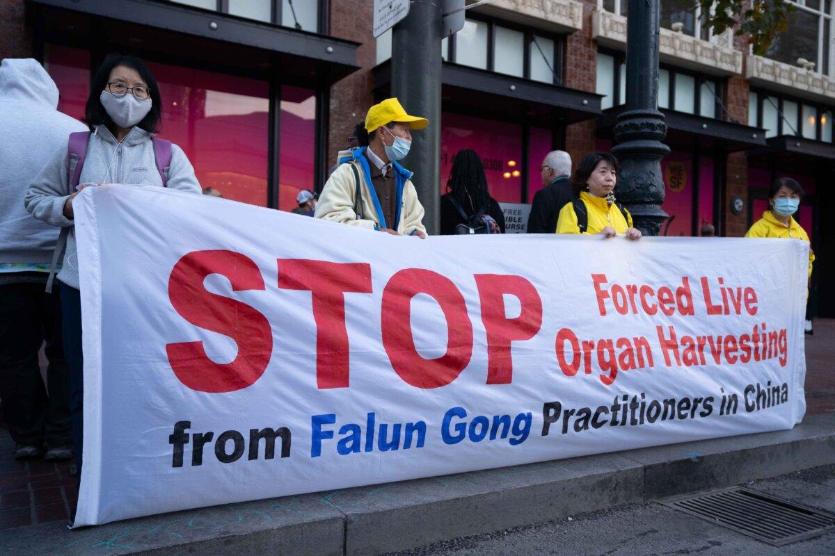 Falun Gong practitioners hold up a banner calling on the Chinese regime to end its state-sanctioned practice of forced organ harvesting, in San Francisco, Calif., on Nov. 14, 2023. (Zhou Rong/The Epoch Times)