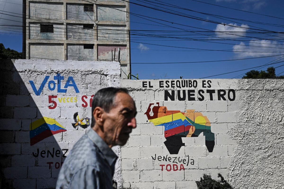 A man walks by a mural campaigning for a referendum to ask Venezuelans to consider annexing the Guyana-administered region of Essequibo, in Caracas, Venezuela, on Nov. 28, 2023. (FEDERICO PARRA/AFP via Getty Images)