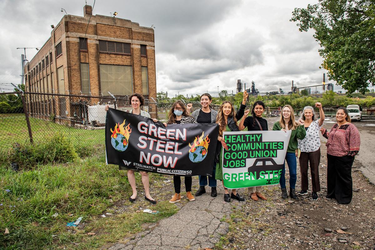 Community members and experts display signs supporting a "green steel" rollout in automaking industries, in River Rouge, Mich., on Sept. 12, 2023. (Aaron J. Thornton/Getty Images for Industrious Labs)