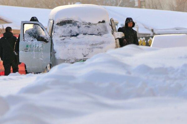 A large amount of snow covers vehicles and roads on the streets of Yantai, Shandong Province, China, on Dec. 16, 2023. (CFOTO/Future Publishing via Getty Images)