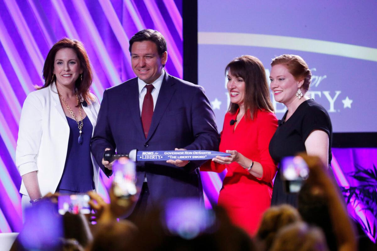 Moms for Liberty founders Tiffany Justice (L) and Tina Descovich (2nd R) present the Liberty Sword to Florida Gov. Ron DeSantis at the Moms For Liberty Summit in Tampa, Fla., on July 15, 2022. (Octavio Jones/Getty Images)