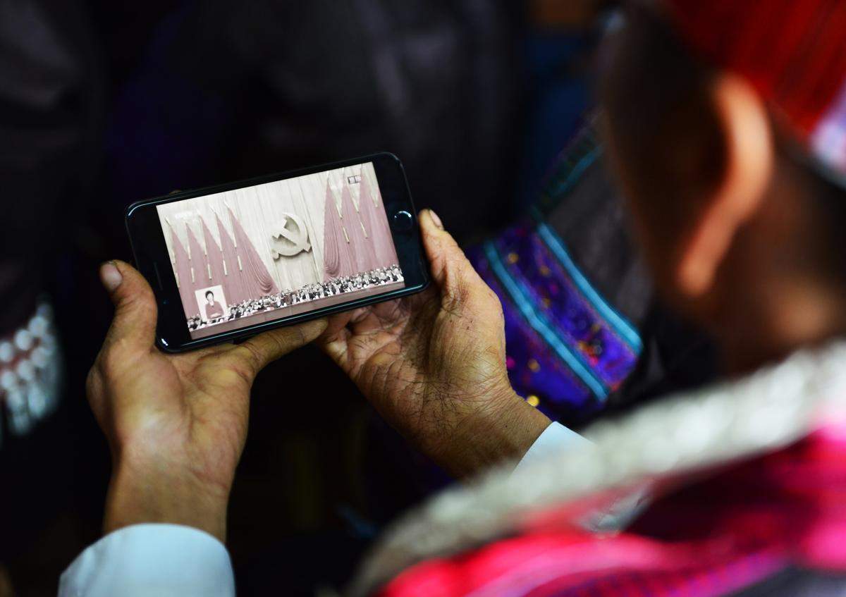 A woman of the Miao ethnic minority watches the opening session of the 19th Communist Party Congress on a smartphone in Jianhe, Guizhou Province, China, on Oct.18, 2017. (STR/AFP via Getty Images)