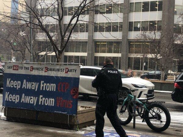 A Toronto Police officer responded to a call for damage on Jan. 23, 2024. A Toronto man was arrested after allegedly vandalizing signs and attacking Falun Gong practitioners outside of a building hosting a Chinese consulate visa application office in the downtown area. (The Epoch Times)