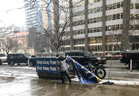 A Toronto man was arrested after allegedly attacking and vandalizing signs of Falun Gong practitioners outside of a building hosting a Chinese consulate visa application office on Jan. 23, 2024. (The Epoch Times)