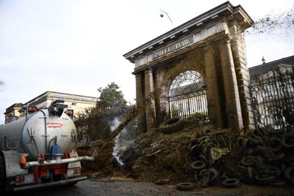 Farmers of the CR47 union (Coordination rurale 47) dump slurry at the entrance to the prefecture in Agen, southwestern France, on Jan. 26, 2024. As they await the French Prime Minister's announcements on Jan. 26, 2024, farmers are blocking many major roads across France. (Christophe ARCHAMBAULT/AFP)