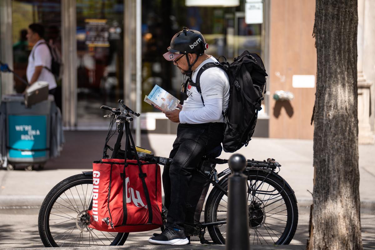 A man reads a flier as Falun Dafa practitioners celebrate World Falun Dafa Day in New York City on May 7, 2023. (Samira Bouaou/The Epoch Times)