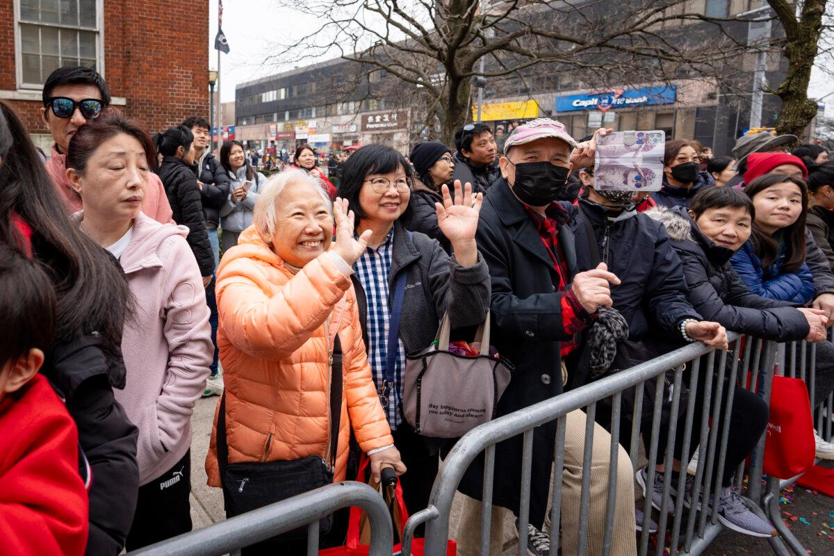 Spectators watch as Falun Gong practitioners attend a parade celebrating the Chinese New Year in the Flushing neighborhood of Queens, N.Y., on Feb. 10, 2024. (Samira Bouaou/The Epoch Times)