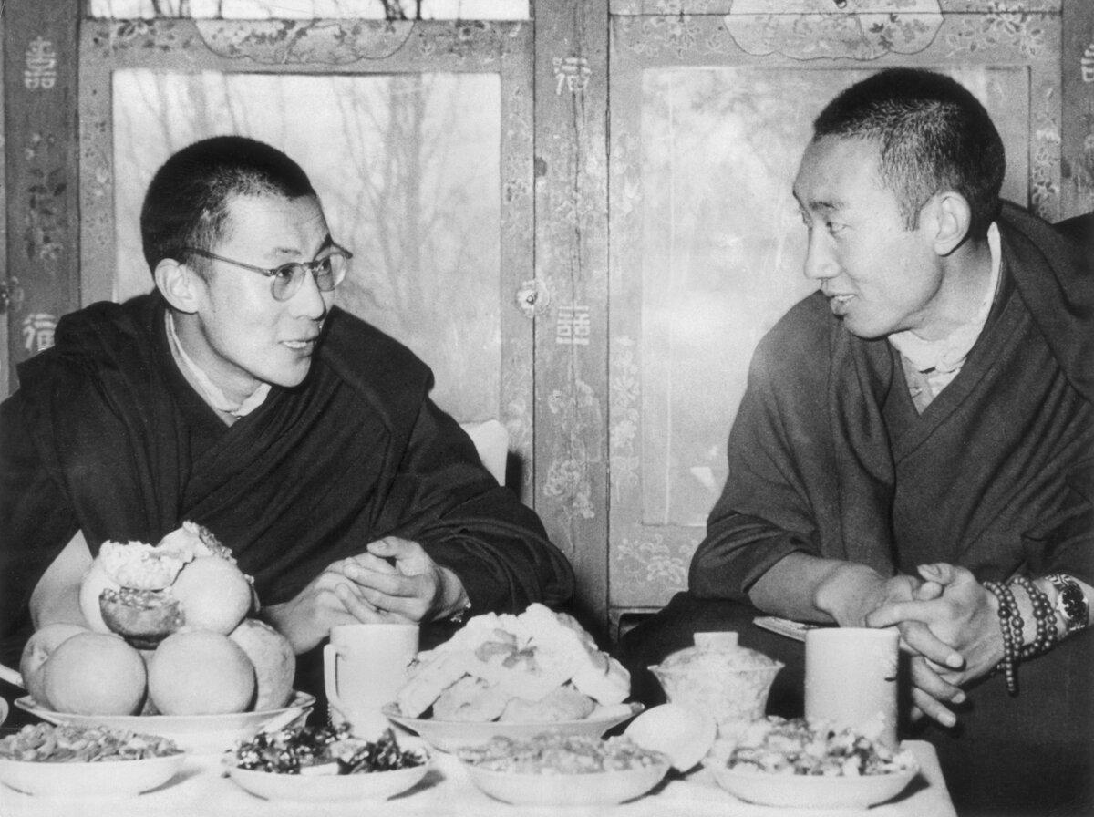 The Dalai Lama of Tibet (Tenzin Gyatso; L) and the Panchen Lama (second in rank as spiritual leader), seated and talking at a dining table in Tibet on May 24, 1954. (Hulton Archive/Getty Images)
