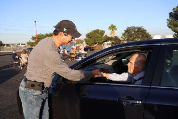 Orange County District Attorney Todd Spitzer shaking the hand of a participant for a Prop. 47 reform signature collection drive-thru event hosted by KFI radio at the Honda Center in Anaheim, Calif., on Feb. 22, 2024. (Mei He/The Epoch Times)