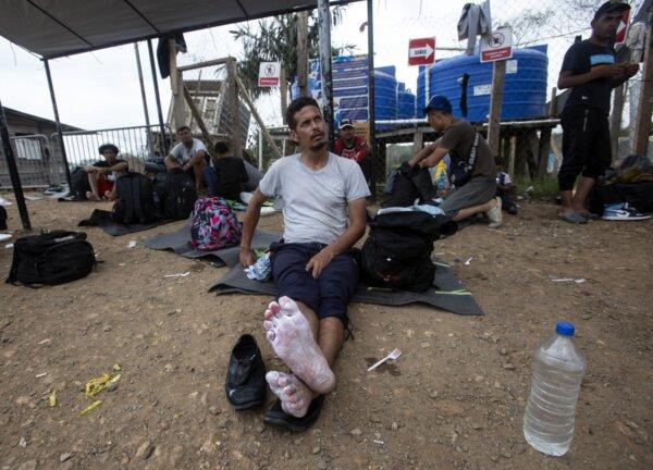 A Venezuelan suffers from sore feet after crossing the Darien Gap at Lajas Blancas in Panama on Feb. 17, 2024. (Bobby Sanchez for The Epoch Times)