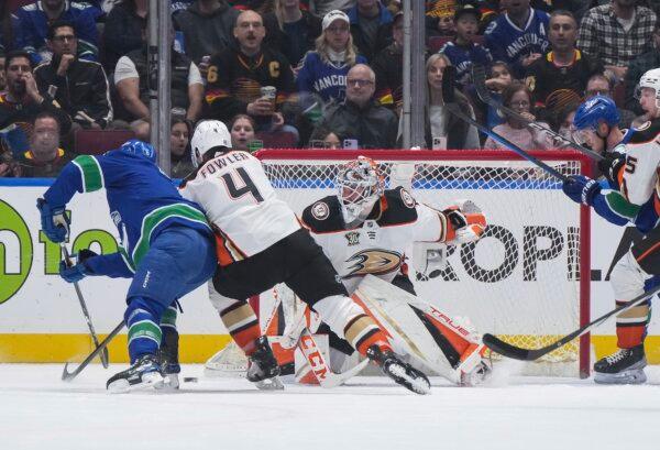 Vancouver Canucks' Brock Boeser (L) scores against Anaheim Ducks goalie Lukas Dostal while being checked by Cam Fowler (4) during the first period of an NHL hockey game in Vancouver on March 31, 2024. (Darryl Dyck/The Canadian Press via AP)
