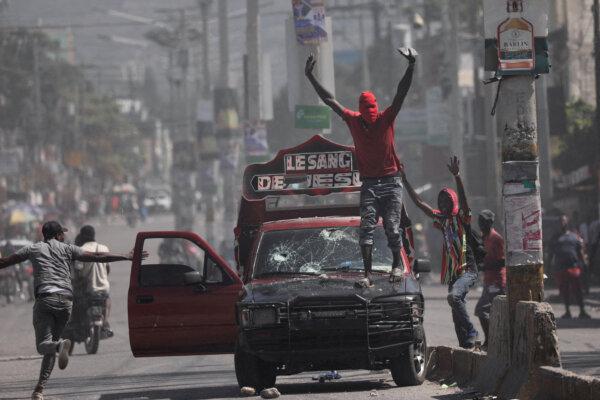 A man with his face covered calls on demonstrators to stop during a protest against Prime Minister Ariel Henry's government and insecurity, in Port-au-Prince, Haiti March 1, 2024. (Ralph Tedy Erol/Reuters)