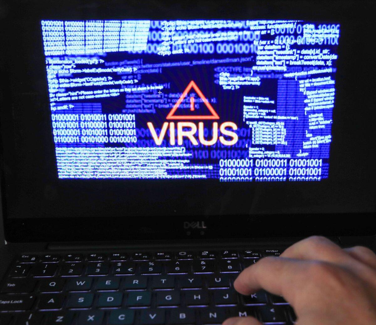 Undated file photo showing a "virus" warning and binary codes on a computer screen. (Peter Byrne/PA)