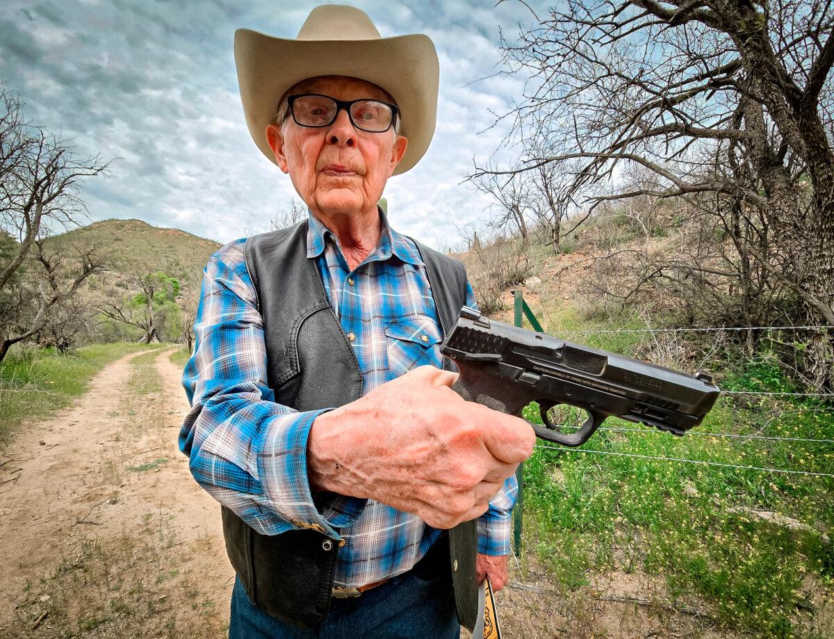 Cattle rancher Jim Chilton displays the 40-caliber handgun he carries when he goes out on his 50,000-acre ranch in Arivaca, Ariz., on March 22, 2024. (Allan Stein/The Epoch Times)