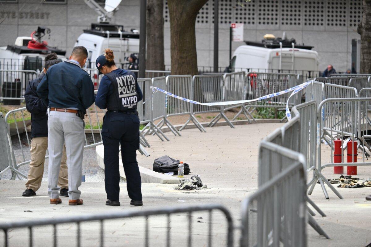 Law enforcement officials investigate the scene after a man reportedly set himself on fire in the park across from Manhattan Criminal Court during the trial of former President Donald Trump, in New York City on April 19, 2024. (Angela Weiss/AFP via Getty Images)