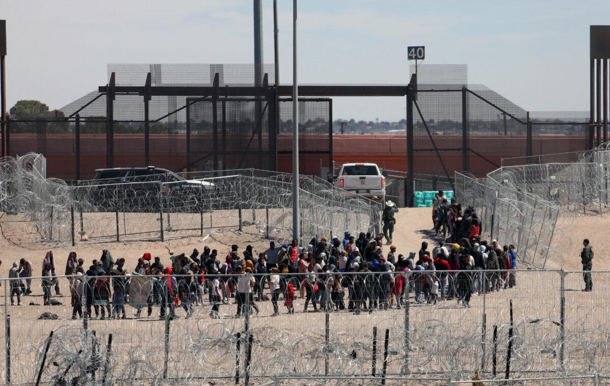 Illegal immigrants line up to be transferred by U.S. Border Patrol after having crossed the Bravo River in El Paso, Texas, as seen from Ciudad Juarez, Mexico, on April 18, 2024. (Herika Martinez/AFP via Getty Images)