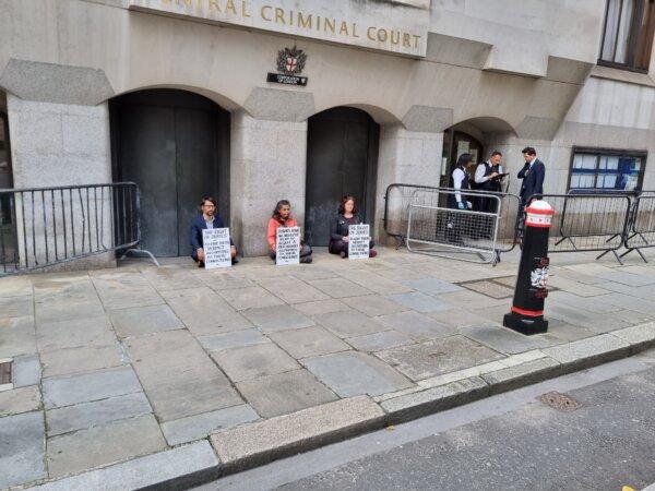 Protesters hold up signs—saying juries are allowed to deliver verdicts according to their consciences—outside the Old Bailey in central London on Sep. 25, 2023. (Chris Summers/The Epoch Times)