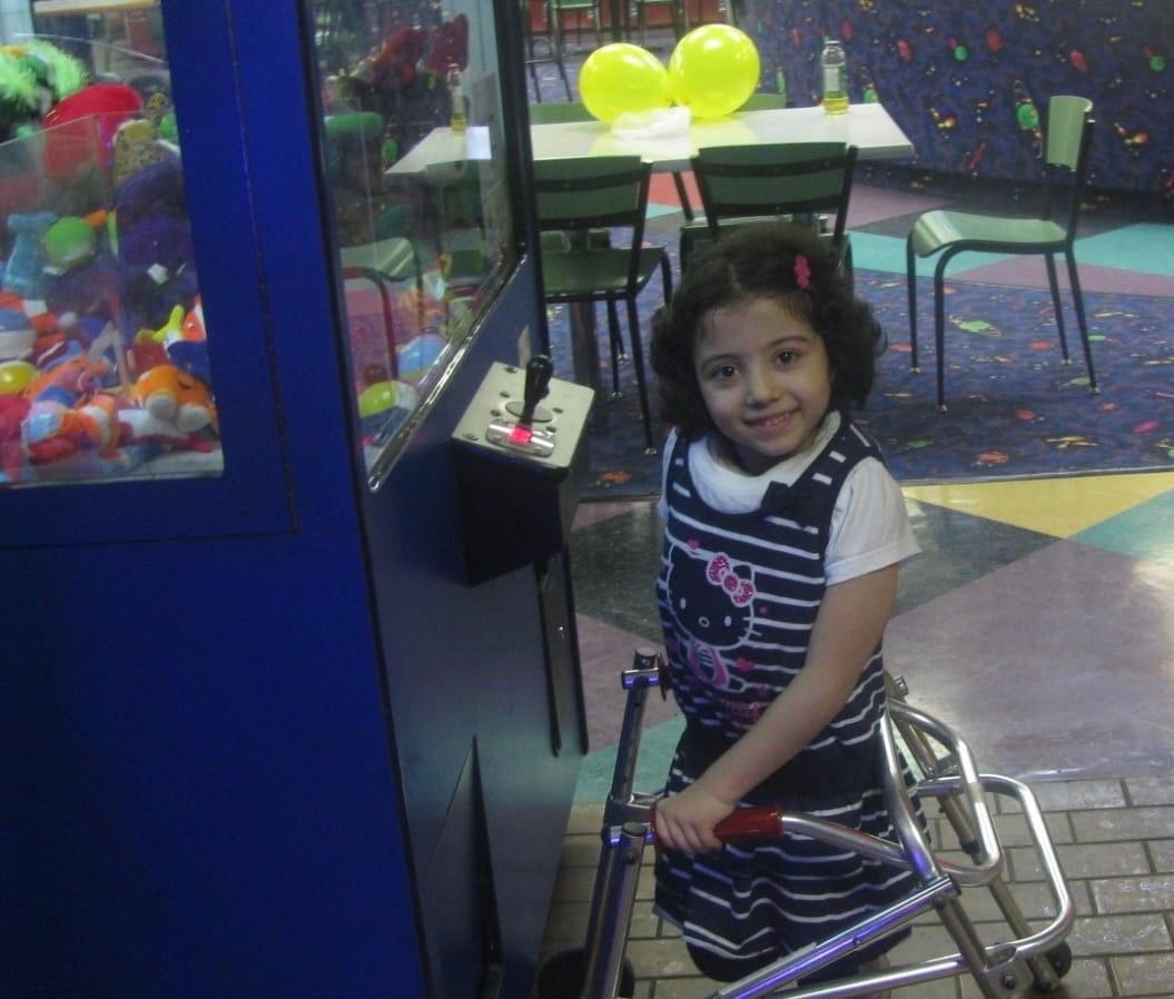 Melika Ghanaati using a walker when she was younger. (SWNS)