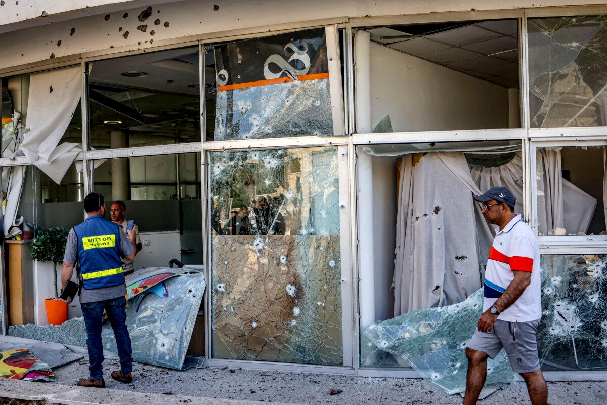 People view the damaged glass facade of a building in the aftermath of intercepted rocket fire launched from Lebanon on Israel in its northern town of Shlomi April 6, 2023. (OREN ZIV/AFP via Getty Images)