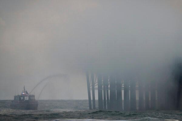 Firefighters try to extinguish a fire burning on the West end of the Oceanside Pier, in Oceanside, Calif., on April 25, 2024. (Sandy Huuffaker/AFP via Getty Images)