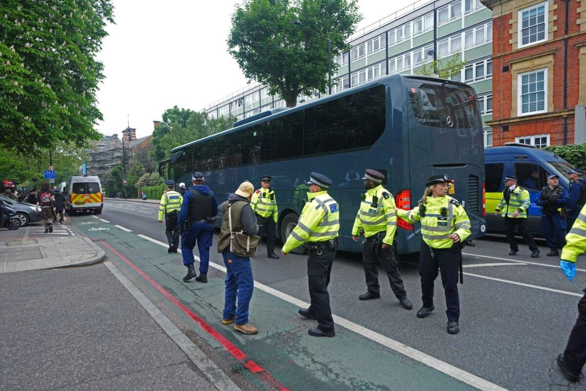 Police officers guard a coach as it arrives outside the Best Western hotel in Peckham, south London, to collect migrants destined for the Bibby Stockholm barge in Dorset, on May 2, 2024. (PA)