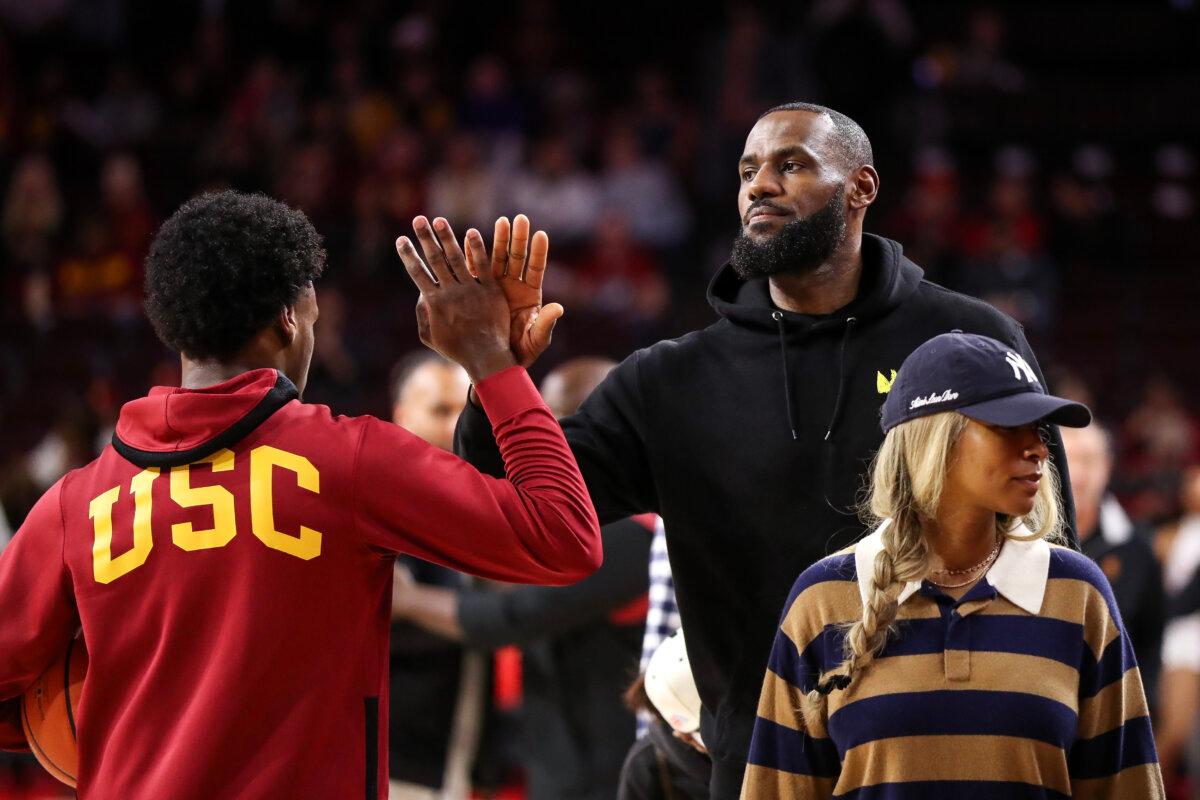 Bronny James #6 of the USC Trojans greets his dad, LeBron James of the Los Angeles Lakers, before the game against the Stanford Cardinal at Galen Center in Los Angeles on Jan. 6, 2024. (Meg Oliphant/Getty Images)