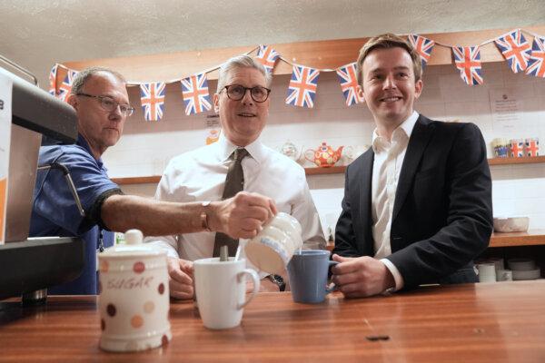Labour Party Leader Sir Keir Starmer (C) has a drink with East Worthing and Shoreham parliamentary candidate Tom Rutland (R), after making his first keynote speech at Lancing Parish Hall in Lancing, England on May 27, 2024. (Stefan Rousseau/PA Wire)