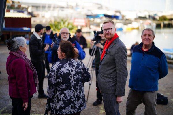 Labour MP Lloyd Russell-Moyle (second from R, in red scarf) on a visit to the Bibby Stockholm accommodation barge at Portland in Dorset, England, on Oct. 30, 2023. (PA)