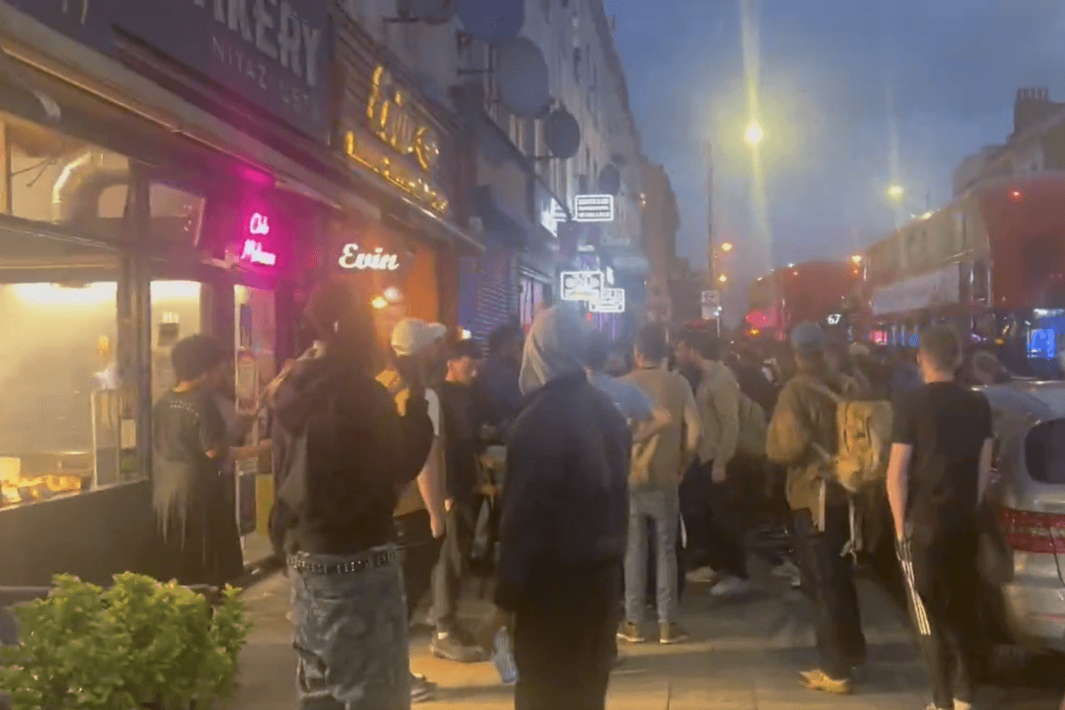 Crowds gathered outside a restaurant after a shooting that injured three adults and a child, in Hackney, London, on May 29, 2024. (Ayo Adesina/PA)