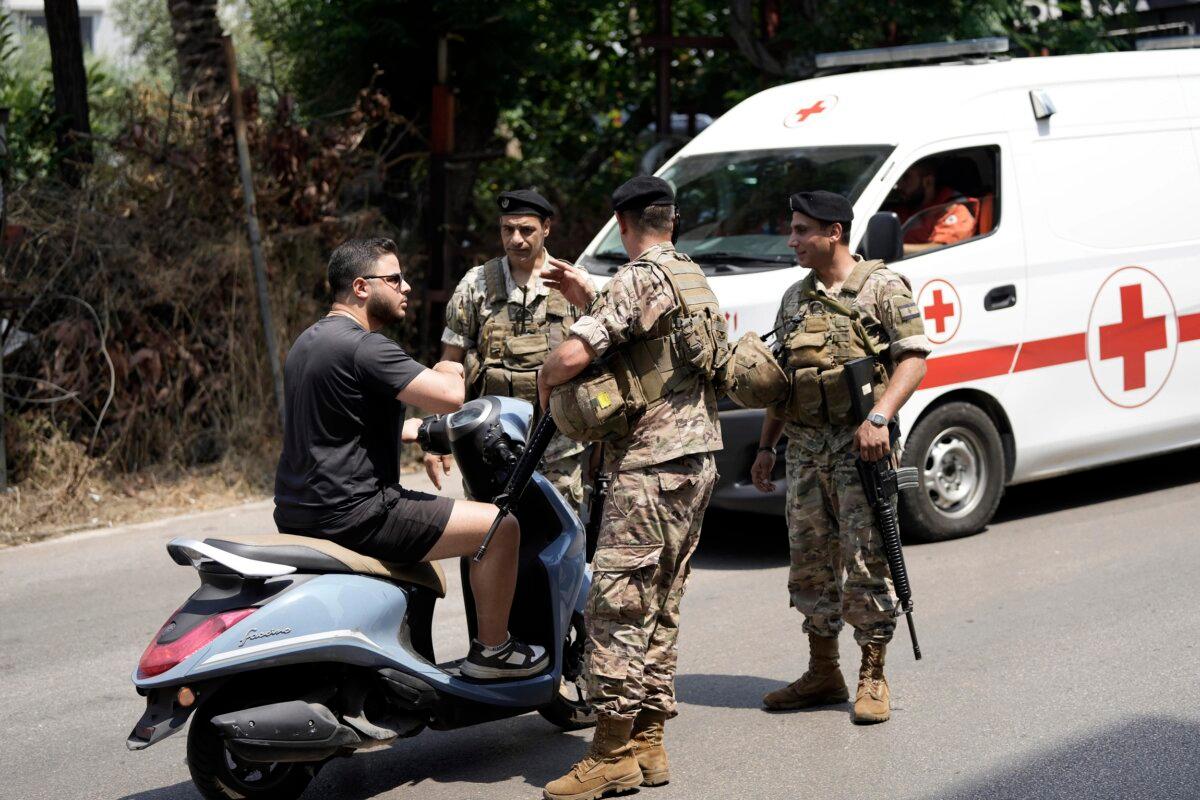 Lebanese soldiers speak to a motorcyclist as they stand guard on a road that leads to the U.S. Embassy in Aukar, a northern suburb of Beirut, Lebanon, on June 5, 2024. (Hassan Ammar/AP Photo)