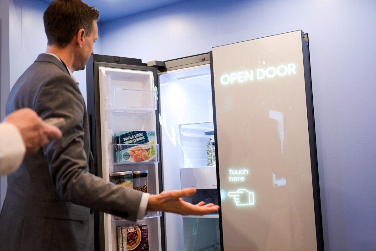 An attendee demonstrates a refrigerator touch door during a preview of Samsung's appliances ahead of the Consumer Electronics Show in Las Vegas, Nevada, on Jan. 3, 2023. (Patrick T. Fallon/AFP via Getty Images)