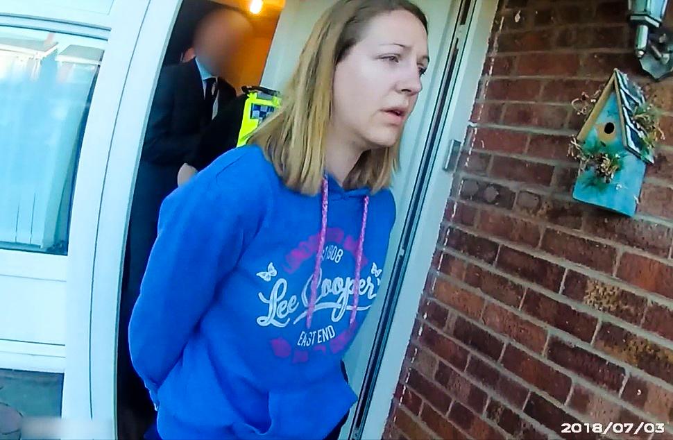 Lucy Letby is led away in handcuffs by police after being arrested at her home in Chester, England, on July 3, 2018. (Cheshire Police)