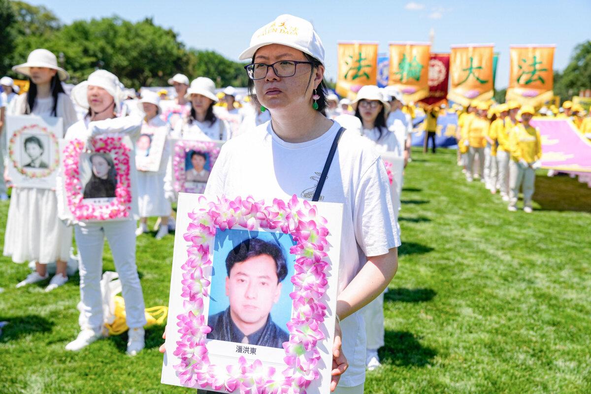 A Falun Gong practitioner holds a wreath commemorating a man who died as a result of the Chinese regime's 25-year-long persecution of the faith group, at a rally in Washington on July 11, 2024. (Larry Dye/The Epoch Times)