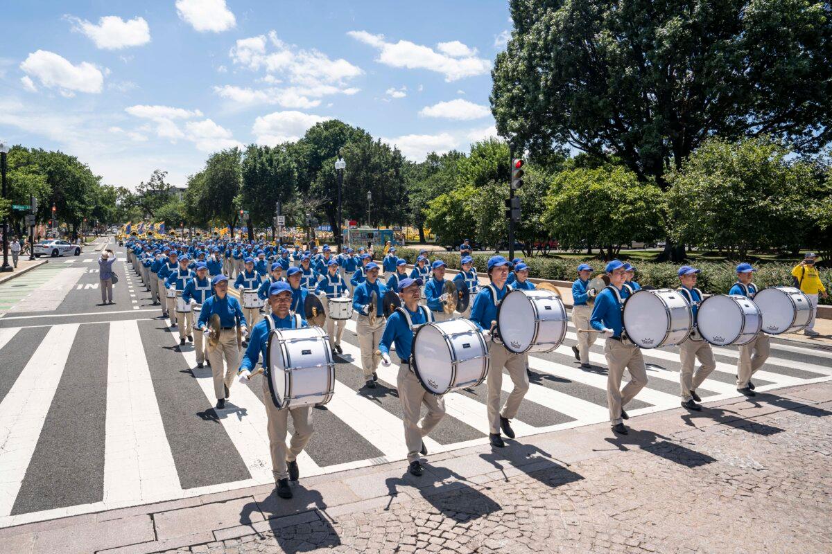 Falun Gong practitioners march during a parade calling for an end to the Chinese Communist Party’s 25-year-long persecution of the spiritual practice at the National Mall in Washington on July 11, 2024. (Madalina Vasiliu/The Epoch Times)