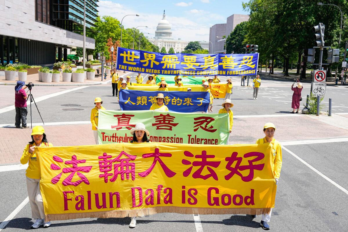 Falun Gong adherents march during a parade calling for the end of the Chinese Communist Party’s 25 years of ongoing persecution of Falun Gong practitioners in China at the National Mall in Washington on July 11, 2024. (Larry Dye/The Epoch Times)
