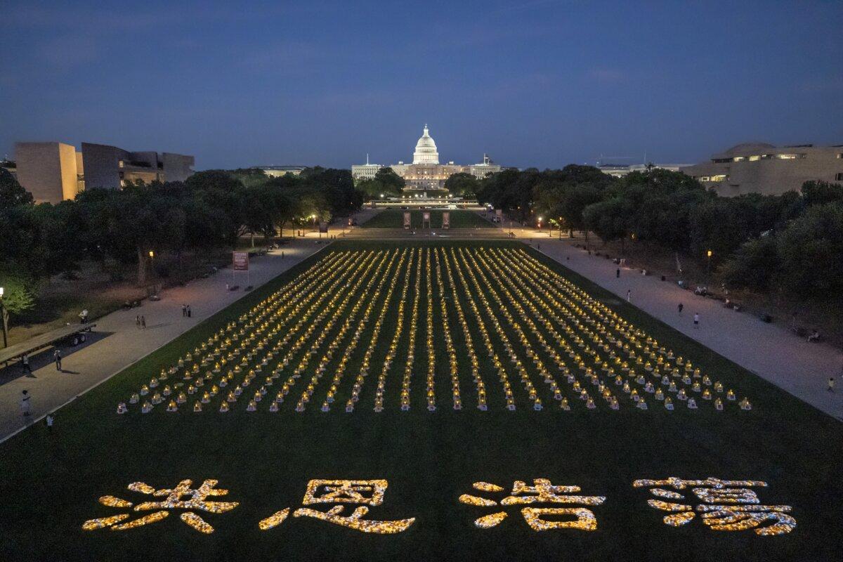 Falun Gong practitioners gather for a candlelight vigil commemorating Falun Gong practitioners' persecution to death in China by the Chinese Communist Party at the National Mall in Washington on July 11, 2024. (Madalina Vasiliu/The Epoch Times)