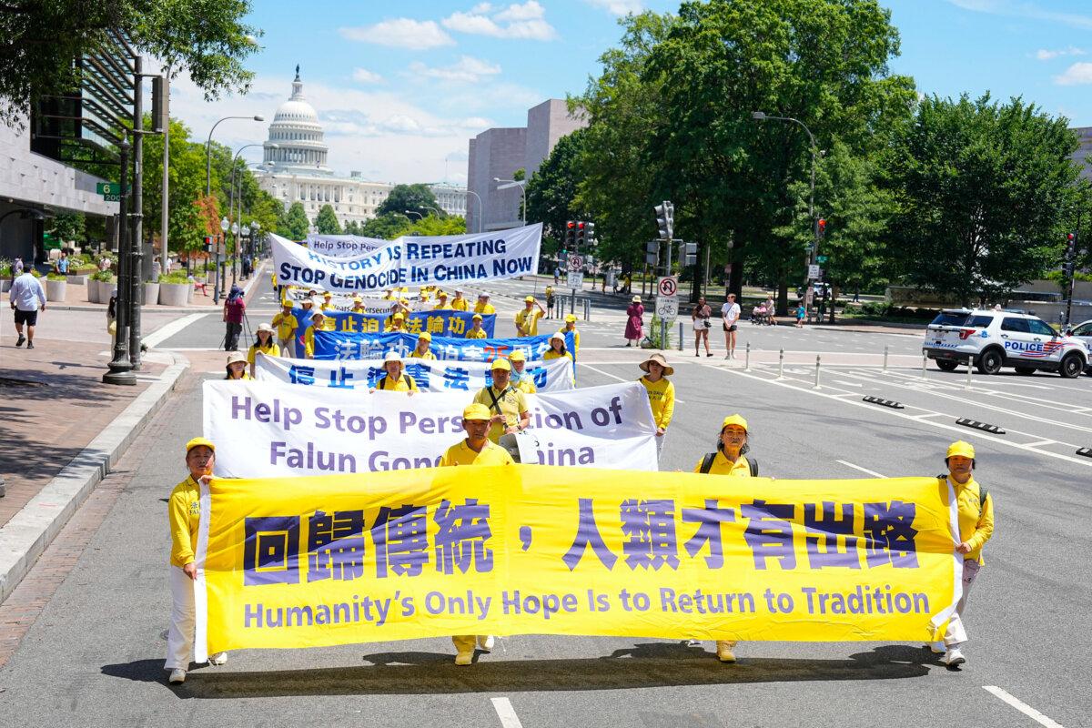 Falun Gong adherents march during a parade calling for the end of the Chinese Communist Party’s 25 years of ongoing persecution of Falun Gong practitioners in China at the National Mall in Washington on July 11, 2024. (Larry Dye/The Epoch Times)